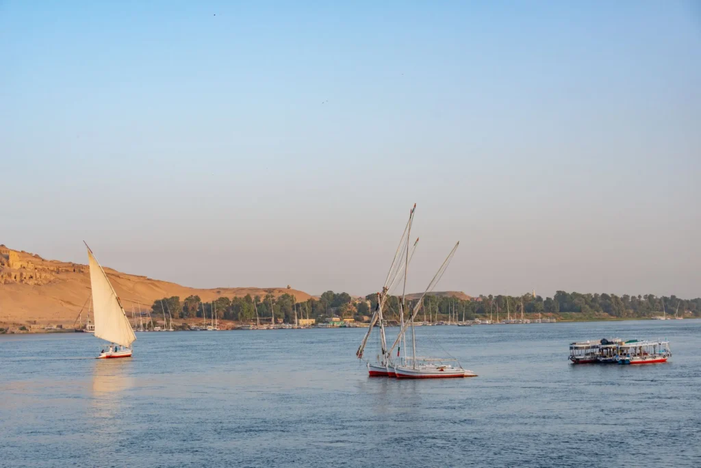 Traditional sailboats crossing the Nile River in Aswan