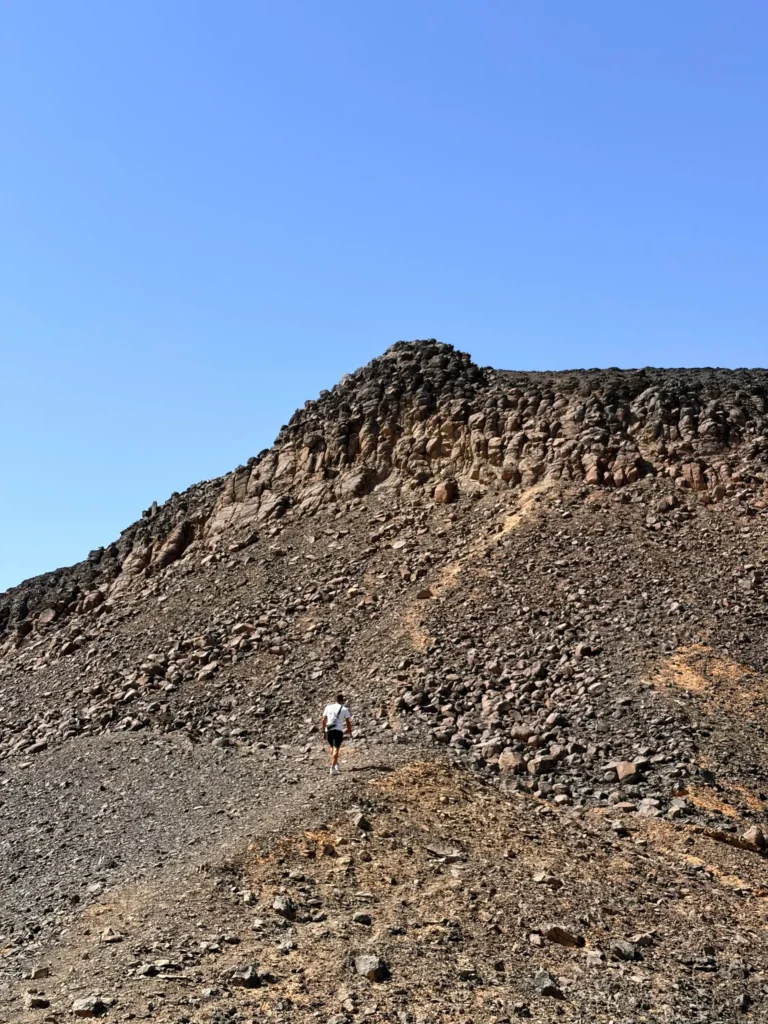 Travelers hiking a volcanic hill in the Black Desert