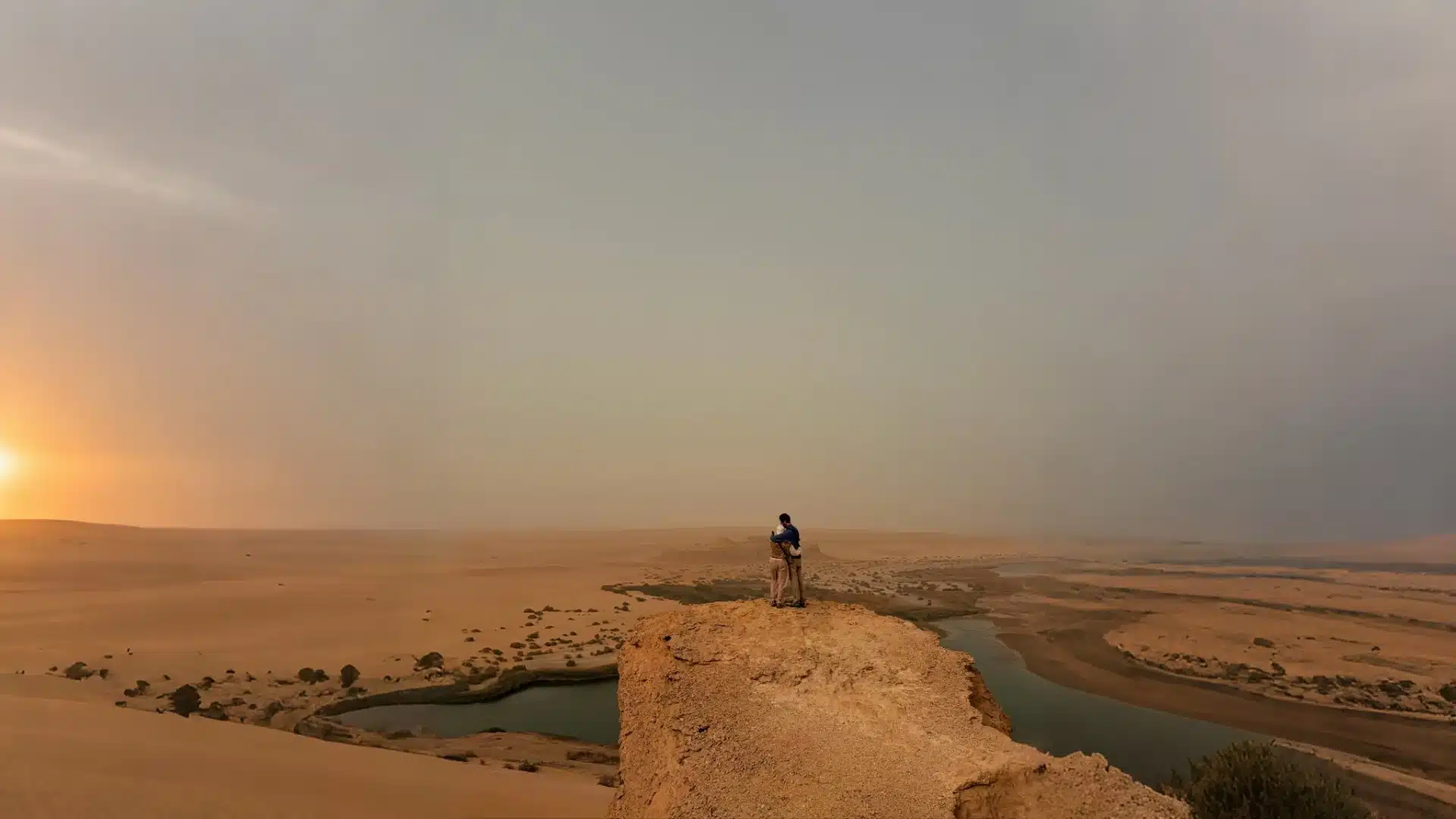 Traveler at a cliff viewpoint above a desert lake at sunset, Fayoum