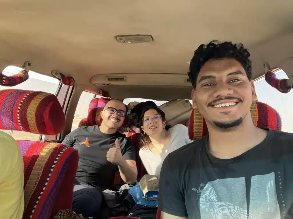 Smiling guests and local guide inside a colorful safari 4x4 in Egypt