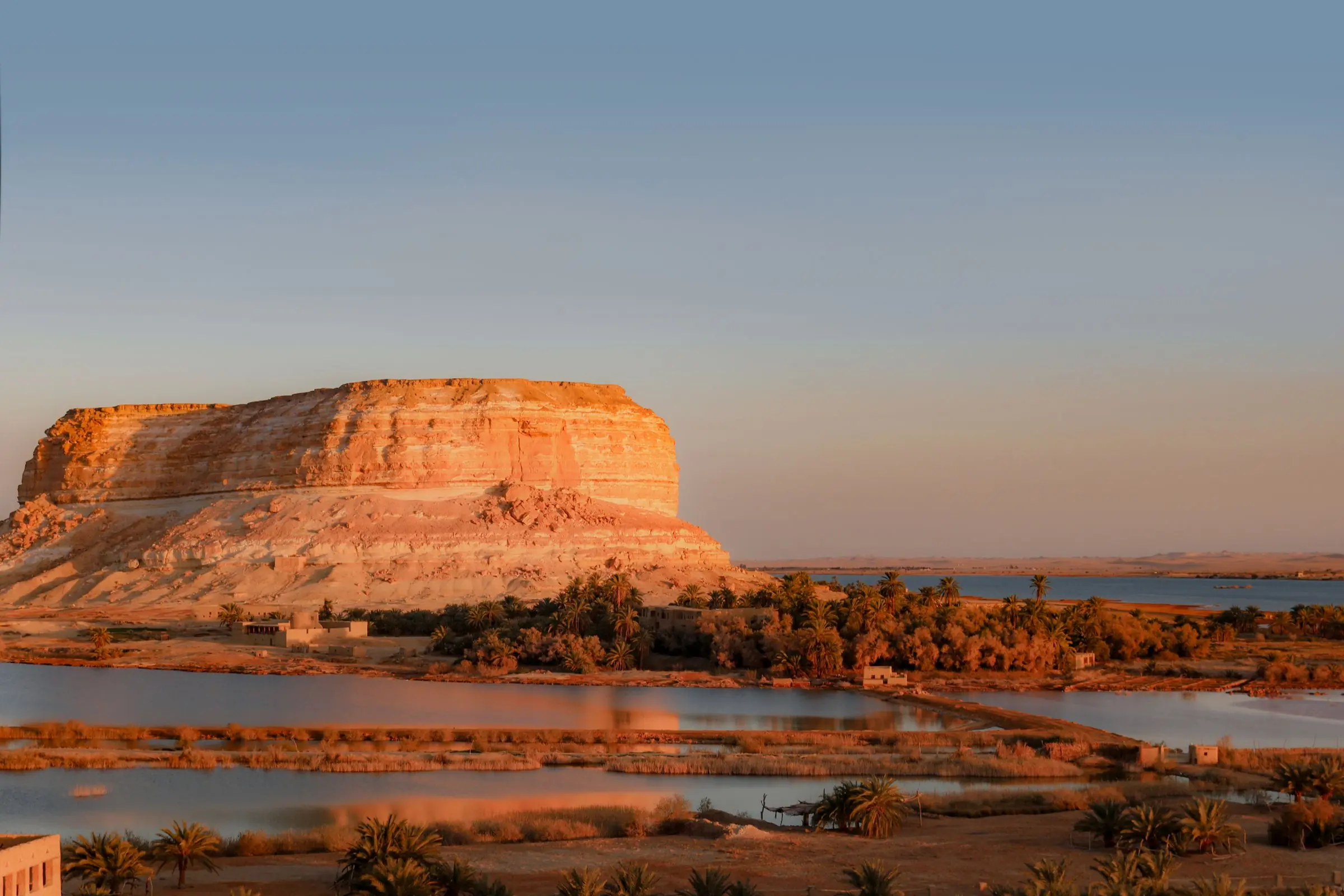 Lake and desert cliffs at sunset in Siwa Oasis