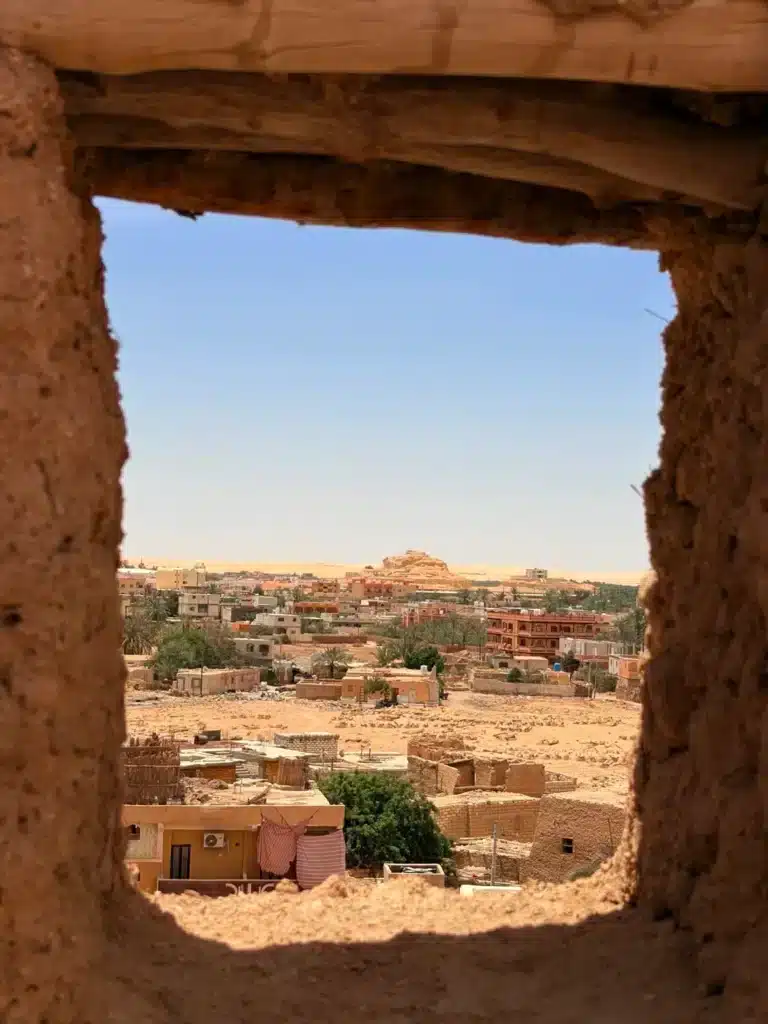 View of Siwa town through an old mud-brick window