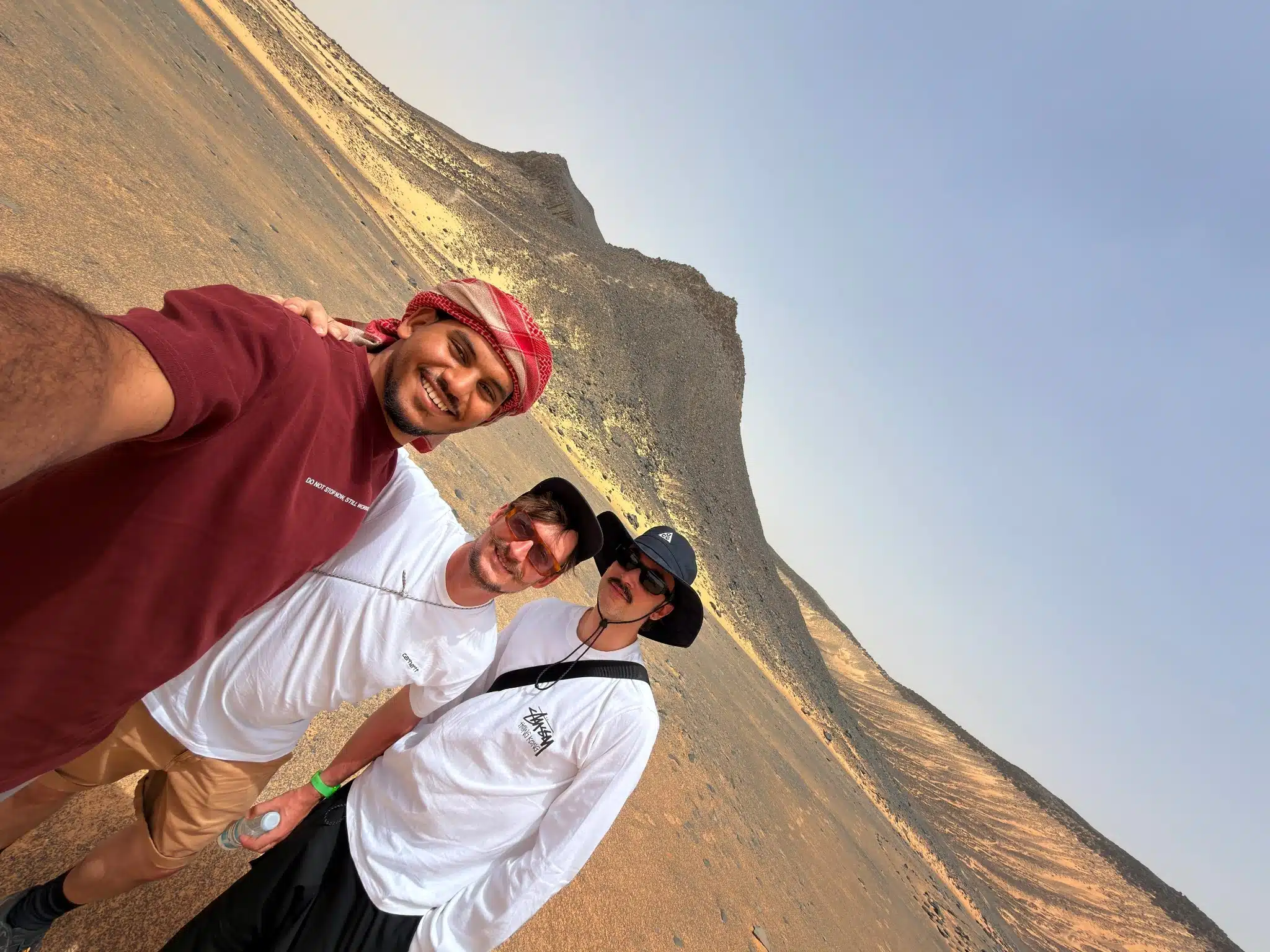 Travel group exploring the rocky volcanic landscape of Egypt's Black Desert