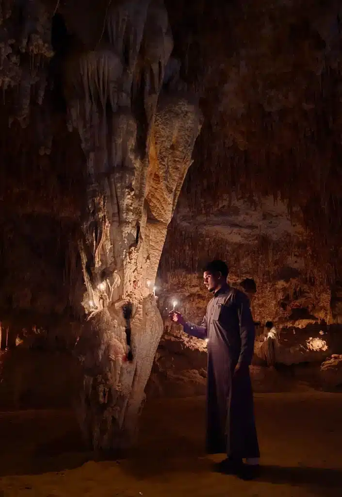 Traveler exploring limestone formations inside Djara Cave in Egypt