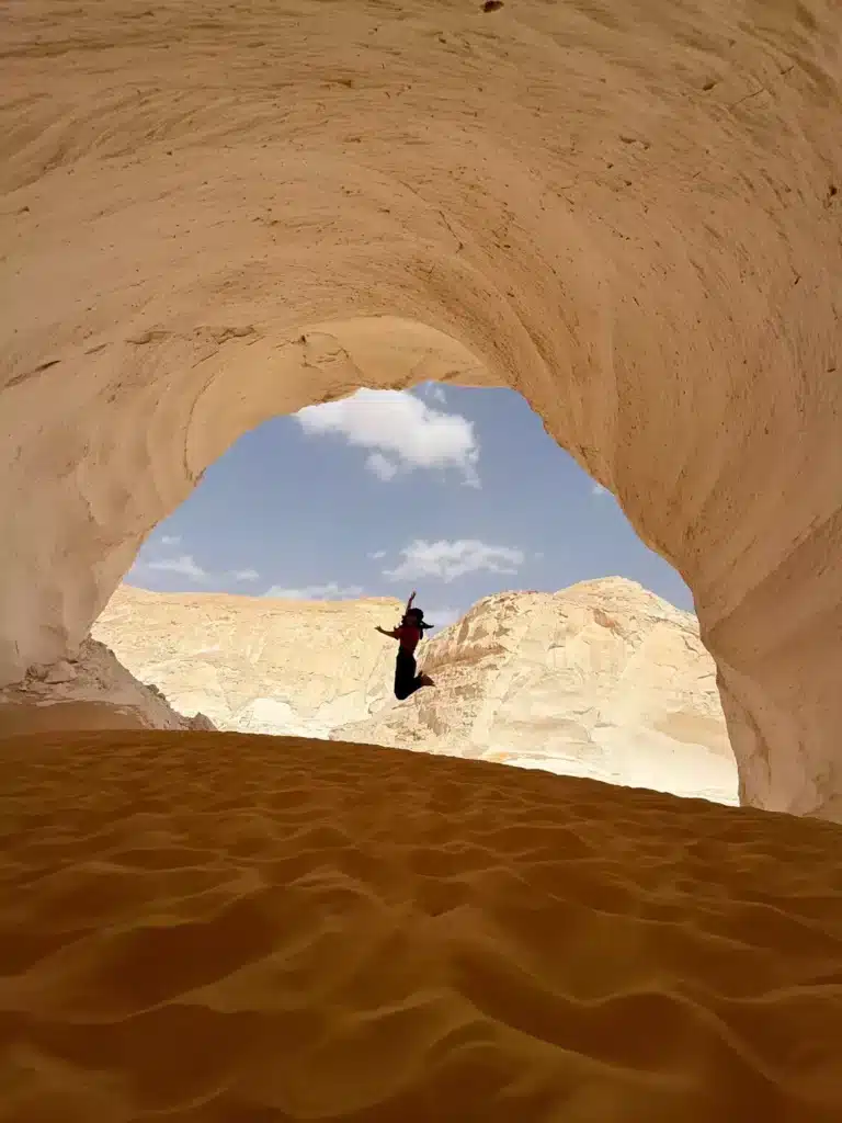 Travelers standing under a natural rock arch in the White Desert